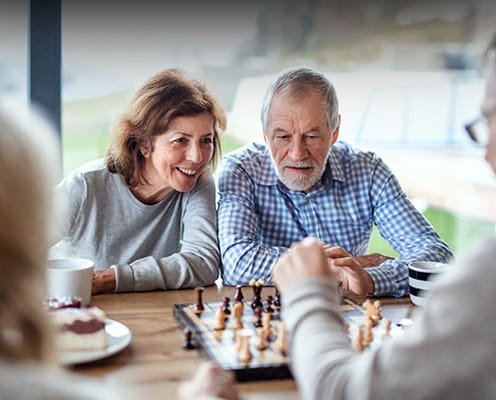 Seniors enjoying a game of chess at a table