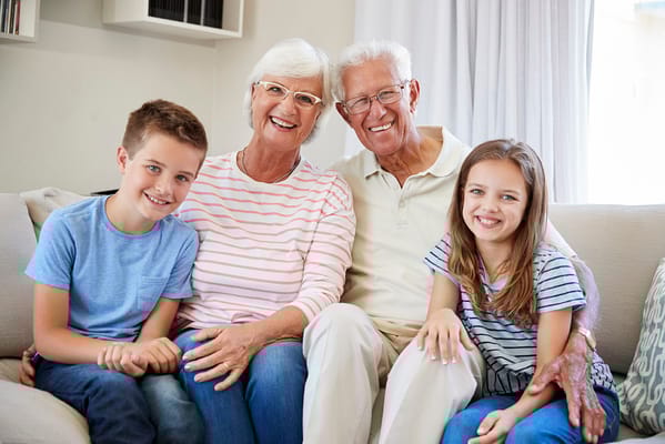 Smiling grandparents with grandchildren in a cozy living room