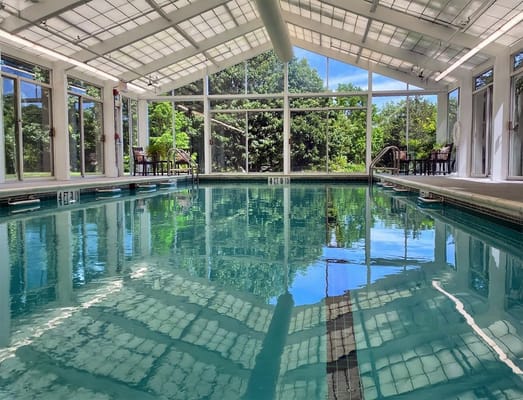 Indoor pool area with large windows and clear water