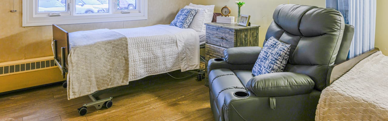 Interior of a resident room with a bed and recliner
