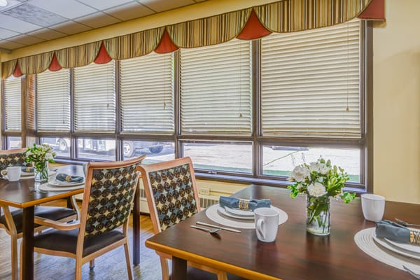 Dining area with neatly set tables and flowers