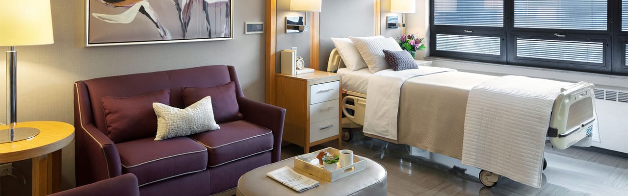 Bright interior of a resident room with a bed and seating