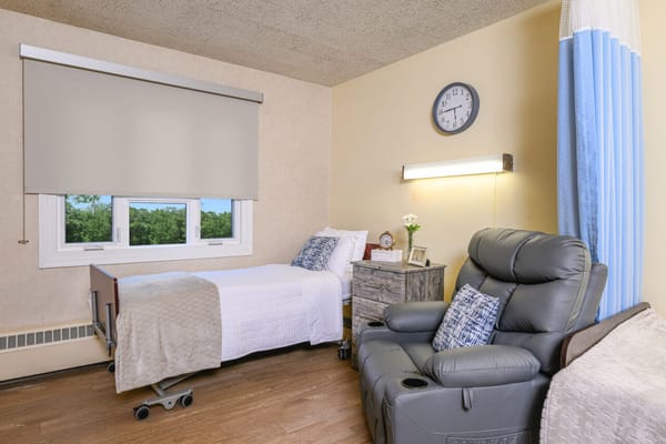 Cozy resident room with a bed and recliner chair