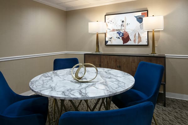 A cozy meeting room with marble table and blue chairs