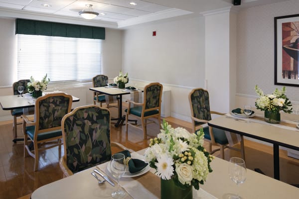 Dining area with neatly set tables and floral arrangements