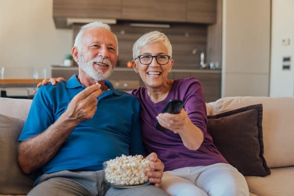 Senior couple enjoying popcorn on the couch