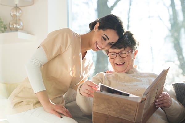 A caregiver and resident enjoying a photo album together