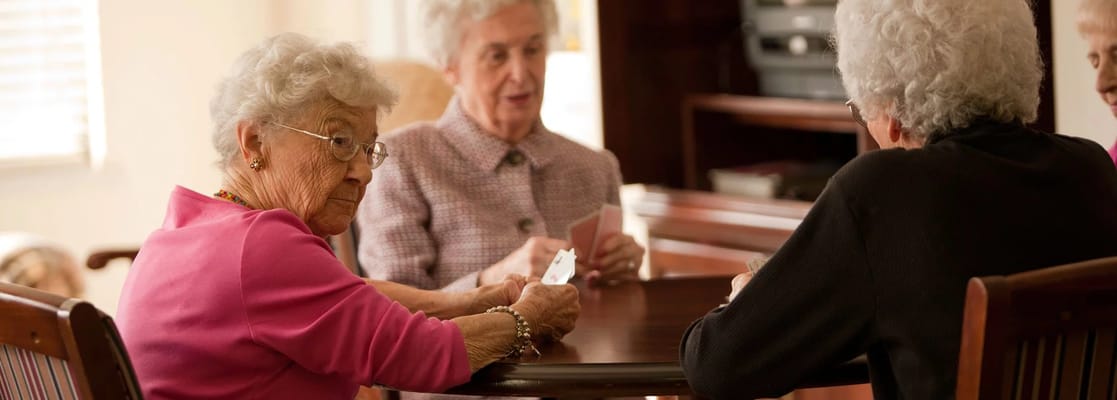 Residents engaged in a card game at a common table