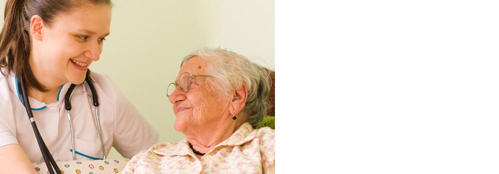 Nurse and elderly resident sharing a joyful moment