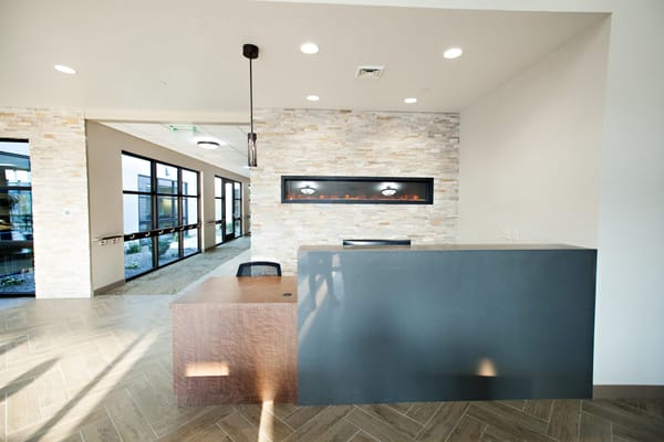 Modern reception area with a stone wall and fire feature
