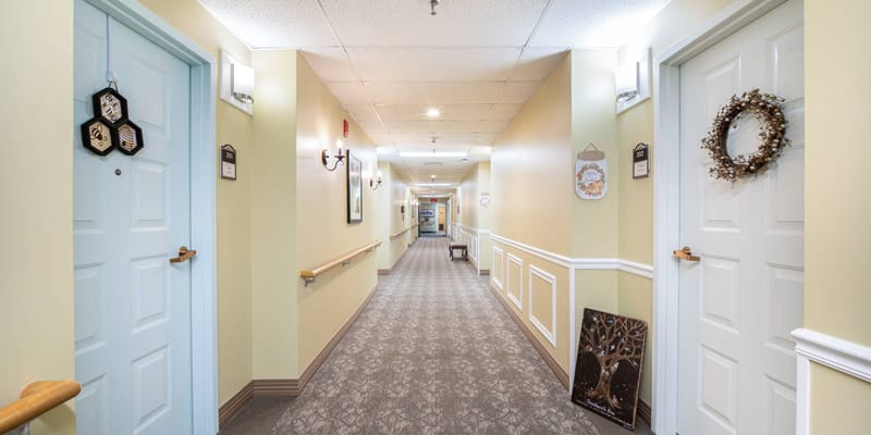 A well-lit hallway with resident doors and decorations
