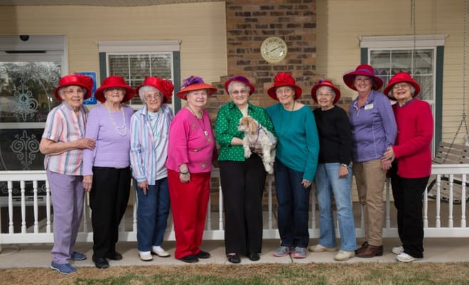 Residents posing together with red hats in an outdoor setting