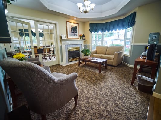 Lounge area with seating and a fireplace at Ascot Park Senior Living