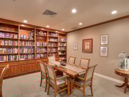Cozy library and dining area with a large bookshelf and dining table.