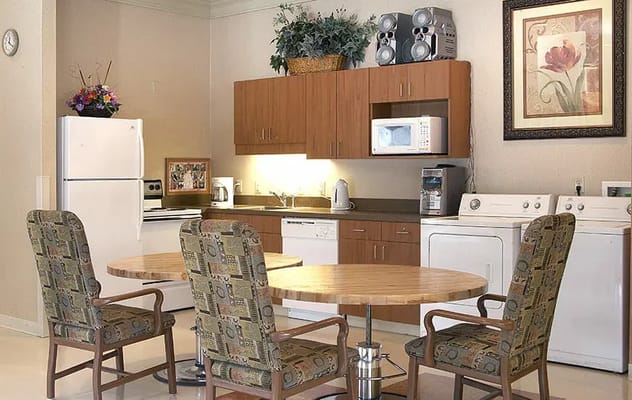 A modern kitchen with dining table and laundry facilities.