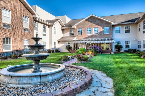 Fountain in a garden surrounded by colorful flowers and greenery