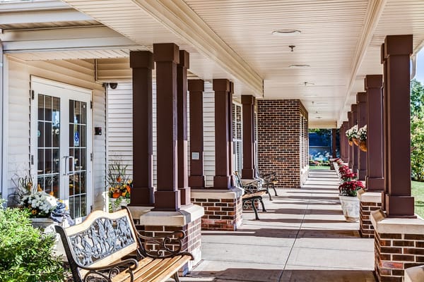 Covered entrance with benches and colorful flowers
