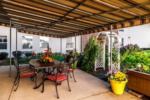 Outdoor patio with seating and flowers at Cedarhurst of Rockford.