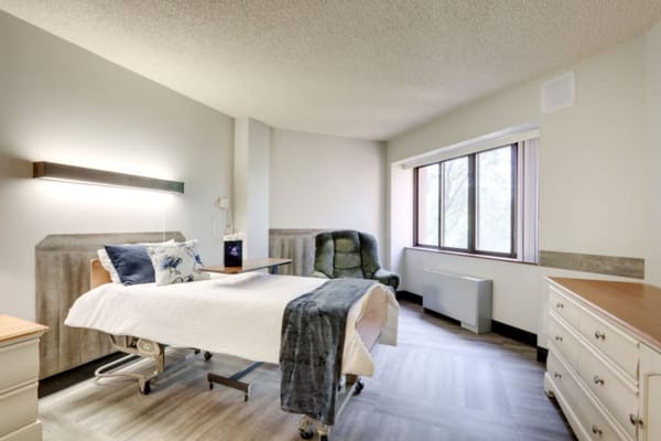 Cozy patient room with bed and recliner