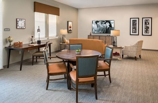 Cozy common area with a dining table and seating, featuring a TV and decorative elements.