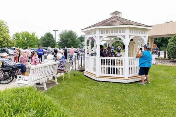 Residents enjoying a performance in a gazebo