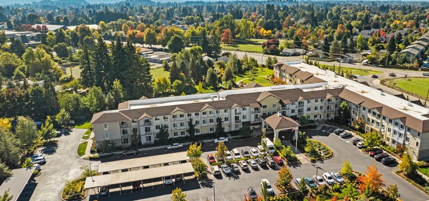 Aerial view of the Crescent Park Senior Living facility surrounded by trees and parking.