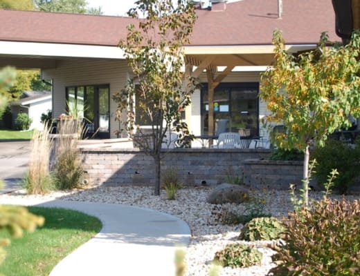 Exterior view of Four Winds Manor with garden path