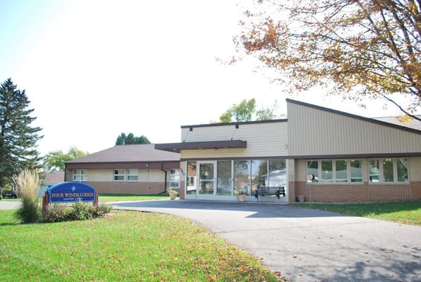 Exterior view of Four Winds Manor facility with landscaping
