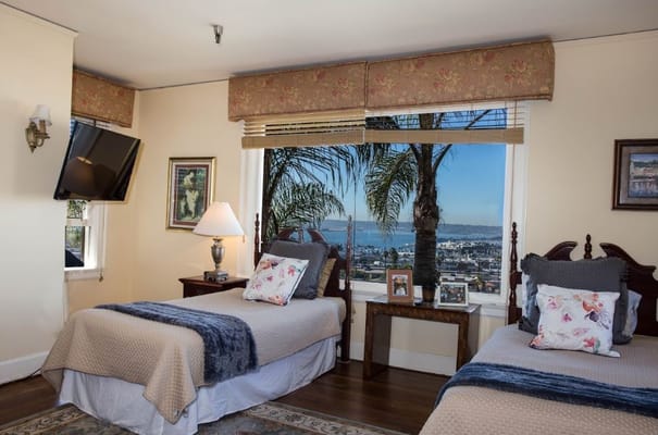 Bright bedroom with two twin beds and a view of the bay.