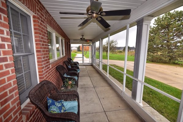 Covered porch with wicker chairs and cushions