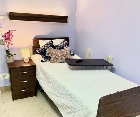 A comfortable bedroom with a bed, nightstand, and decorative pillows.