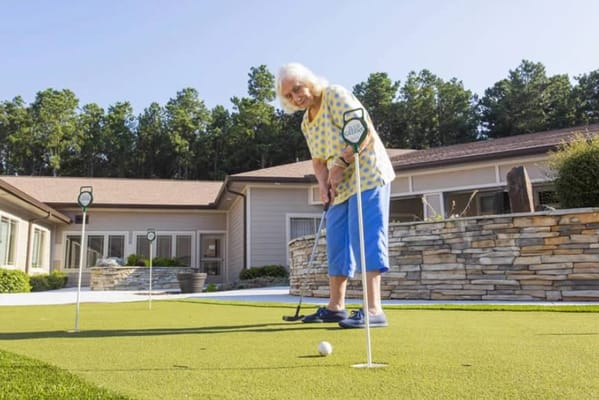 Resident playing golf on the outdoor putting green