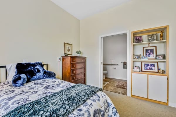 Cozy bedroom featuring a bed with floral bedding and a storage unit