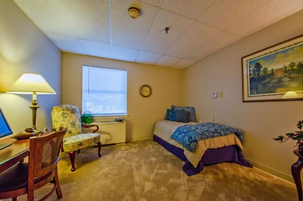 Cozy private resident room with a bed and chair