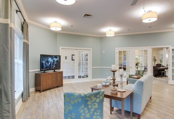 Common area with seating and TV in a light-colored room