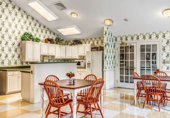 Bright dining area with wooden tables and floral wallpaper