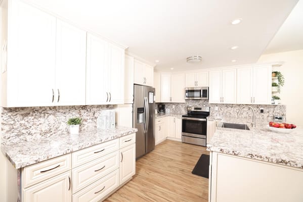 Spacious kitchen with white cabinets and granite countertops