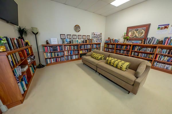 A comfortable seating area in the library with bookshelves.