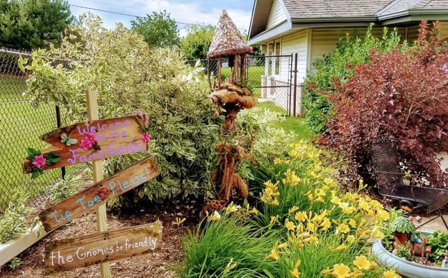 Colorful fairy garden with a wooden sign and flowers
