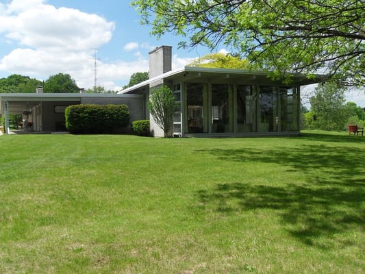 Modern building exterior surrounded by grassy lawn and trees