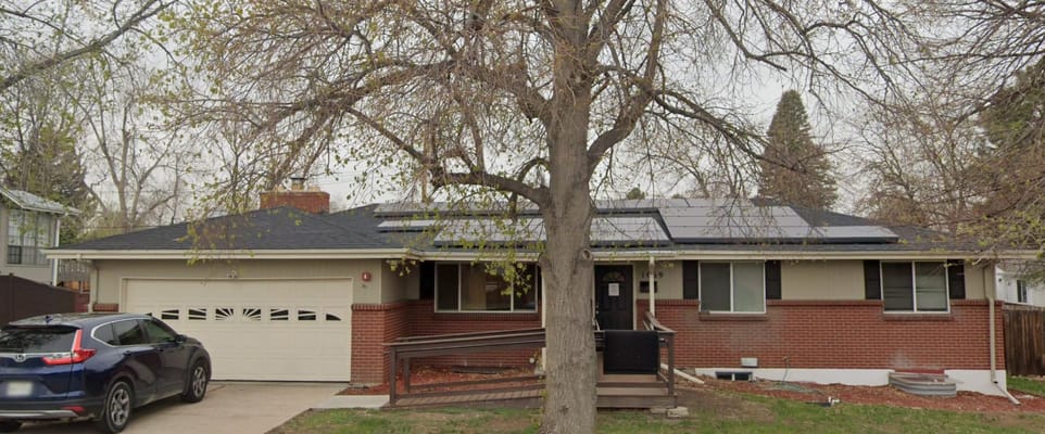 Front view of Tender Care Assisted Living with a tree and parked car.