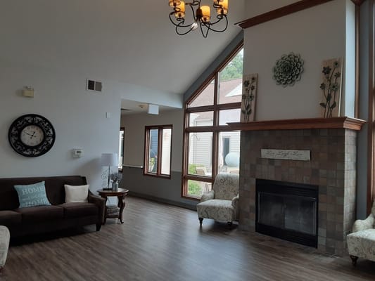 Bright and cozy common area with seating and fireplace