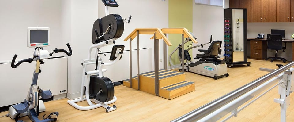 Gym equipment including stationary bikes and a stair challenge at The Grove Elmhurst.
