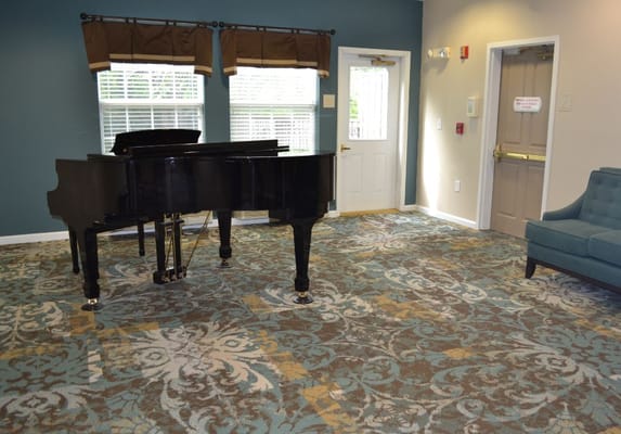 Interior view of a common area with a piano and seating