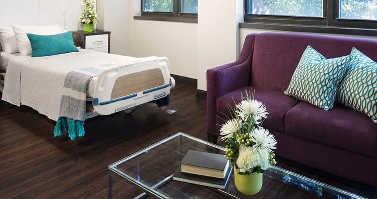 A cozy residential room with a bed and seating area