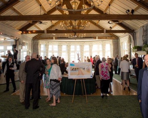 Residents and guests mingling at an event in a large hall