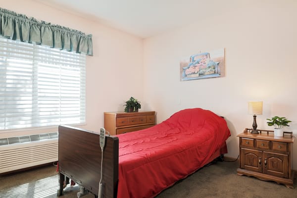 Cozy resident room with a red bedspread