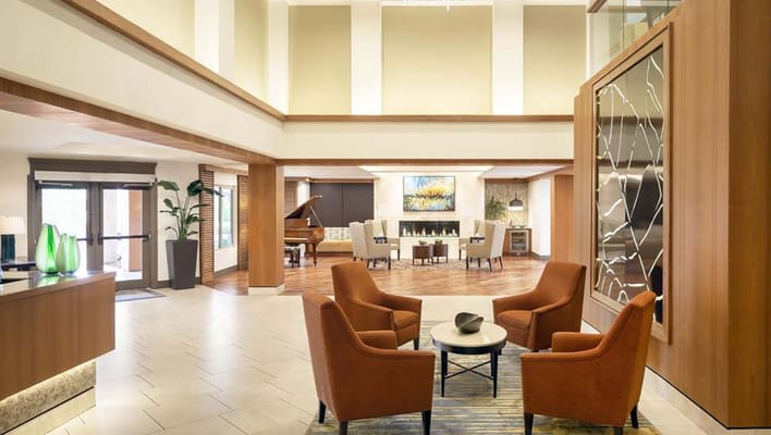 Bright and welcoming lobby with seating and a grand piano