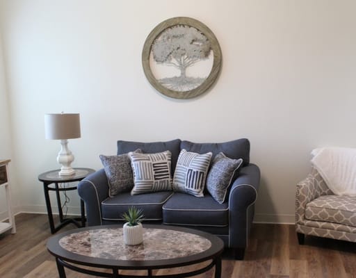 Cozy living room with blue couch, decorative pillows, and coffee table