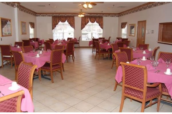 Dining area with pink tablecloths and wooden chairs